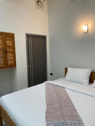 a bedroom with two beds and a door at NIRAN Hotel & Residence in Ban Talai