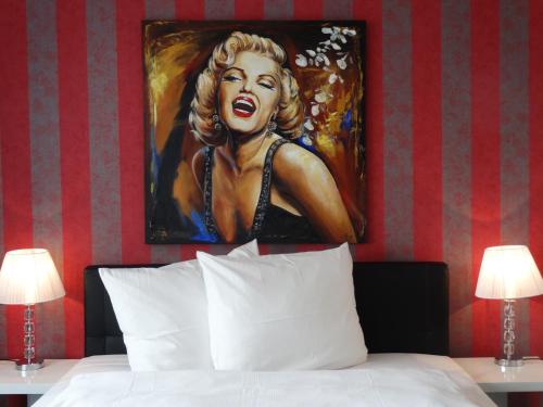 a painting of a woman is above a bed at Hotel Stay in Essen