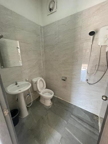 a bathroom with a shower and a toilet and a sink at NIRAN Hotel & Residence in Ban Talai