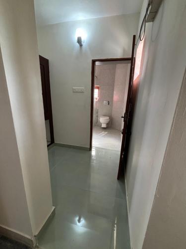 a hallway with a bathroom with a toilet and a mirror at Ushas Homestay in Trivandrum