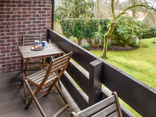 a table and two chairs on a balcony with a table and chairs at Bittern Lodge in Cromer