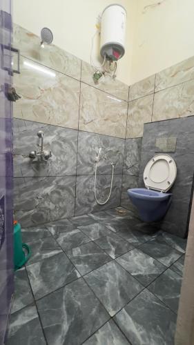 a bathroom with a blue toilet and a shower at Hotel Madurai Comforts in Madurai