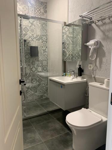 a bathroom with a toilet and a sink and a shower at Seven Rooms Hotel in Tbilisi City