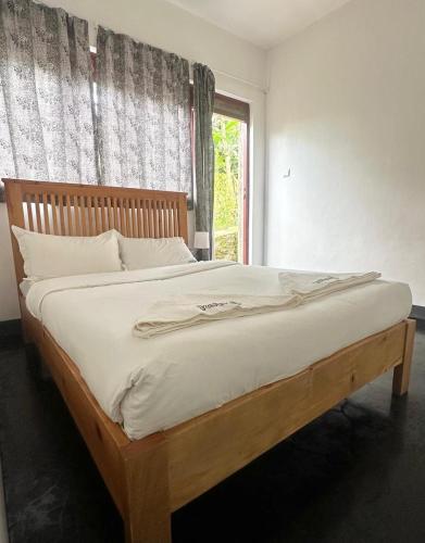 a bedroom with a bed with a wooden frame and a window at Koi Koi, Fort Portal in Fort Portal