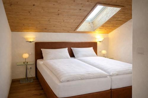 a bedroom with a large white bed with a skylight at Ferienwohnung Kramerblick Marienplatz in Garmisch-Partenkirchen