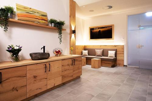 a bathroom with a sink and a couch in a room at Vital Hotel Post in Dienten am Hochkönig