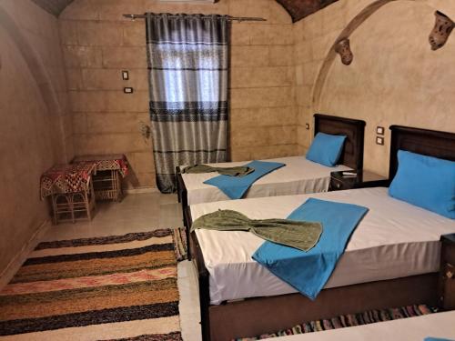 two beds in a room with a window at Labib Guest house in Aswan