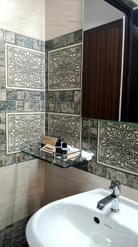 a bathroom with a sink and a mirror at White Dove Luxurious Boutique Hotel, within 3 Km from Guwahati Airport in Guwahati