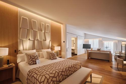 a bedroom with a large bed and a desk at Hospes Palau de La Mar, Valencia, a Member of Design Hotels in Valencia