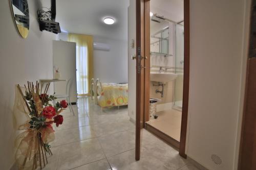 a room with a hallway with a mirror and a vase of flowers at Hotel da ettore in Porto Cesareo