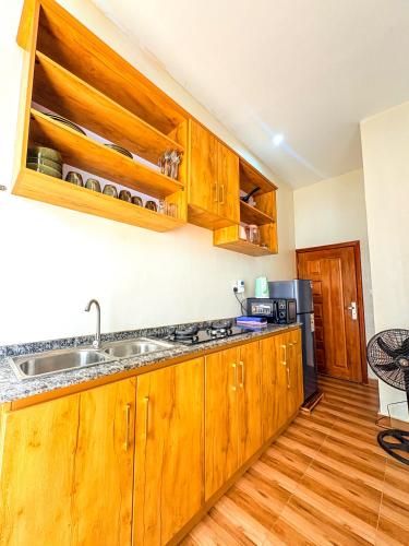 eine Küche mit Holzschränken und einer Spüle in der Unterkunft Amici Residence in Kigali