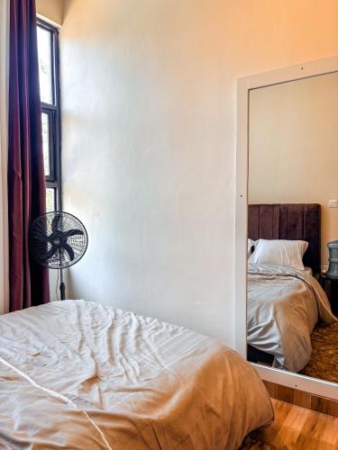 ein Schlafzimmer mit einem Bett und einem Spiegel in der Unterkunft Amici Residence in Kigali