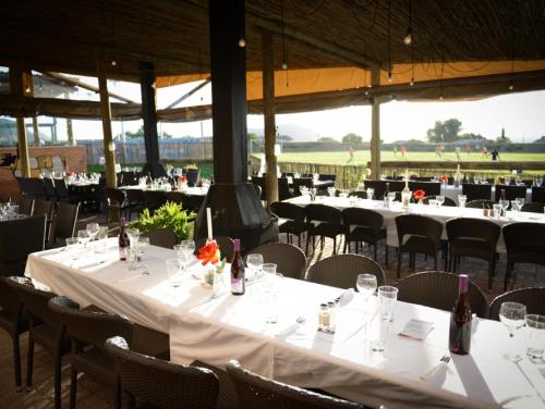 a group of tables and chairs with wine bottles at Hokahanya Inn & Conference Centre in Maseru