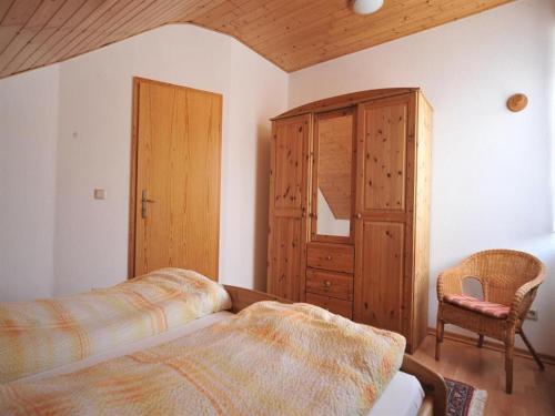 a bedroom with a bed and a wooden cabinet at Ferienweingut Hammes in Mülheim an der Mosel