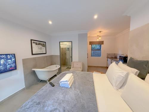 a bathroom with a bed and a tub in a room at Amoris Guesthouse I - Randburg in Johannesburg