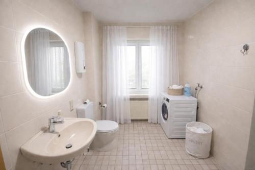 a white bathroom with a sink and a toilet at Comfort Stay Koblenz in Koblenz