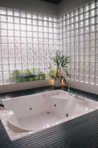 a bath tub in a bathroom with a large window at Liorasuite 4 Bedroom Jacuzzi Billiard Pingpong in KBP in Padalarang