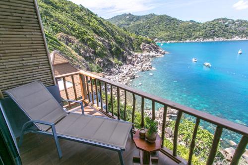 a balcony with a chair and a view of the water at Sai Daeng Resort in Koh Tao
