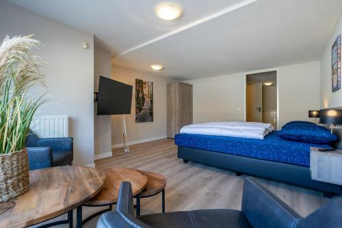 a bedroom with a bed and a table and chairs at Kabbelaarsbank 2C - Port Marina Zélande in Ouddorp