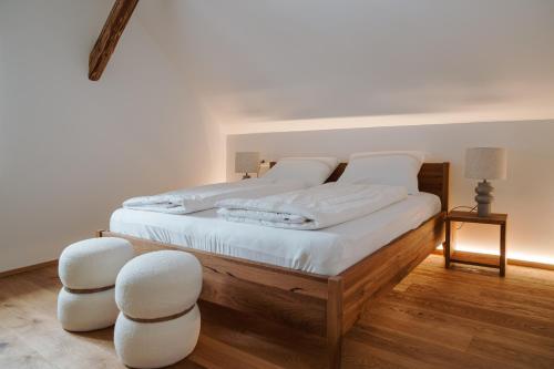 a bedroom with a bed with white sheets and two white chairs at Apartmaji Matec in Fala