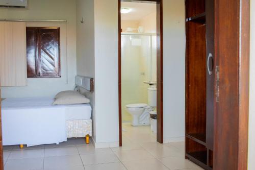 a small bedroom with a bed and a toilet at Hotel Pousada Dos Ventos in Parnaíba