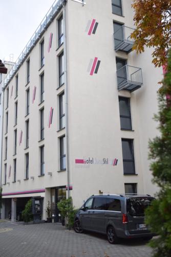 a van parked in front of a building at Hotel Jungstil in Darmstadt