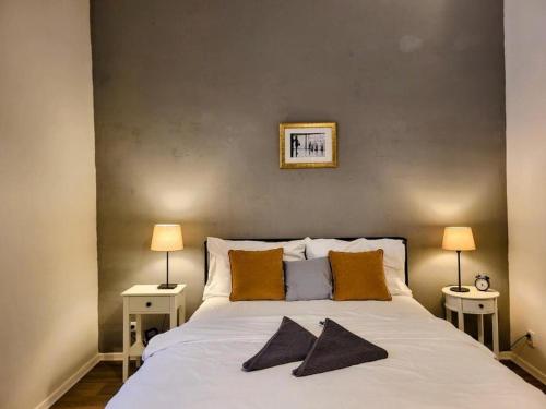 a bedroom with a large white bed with two lamps at Urban Jungle in Brno