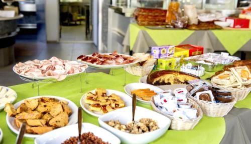 a table topped with lots of different types of food at Camping Village Baia Azzurra in Castiglione della Pescaia