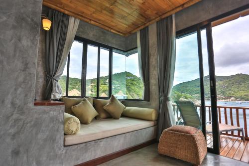 a room with a couch in a room with windows at Sai Daeng Resort in Koh Tao