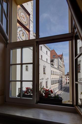 an open window with a view of a clock tower at Gotikhotel Frenzelhof in Görlitz
