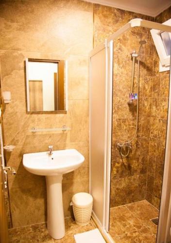 a bathroom with a sink and a shower at Hotel Gumbet in Bodrum City