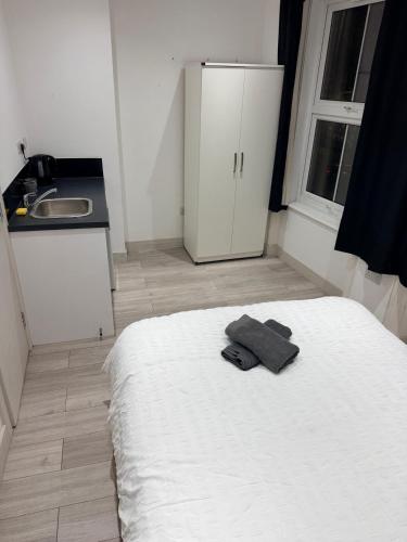 a bedroom with a white bed and a sink at Modern Studios Elephant and Castle in London