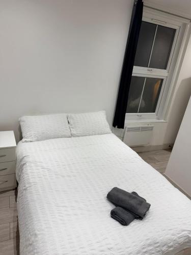 a bedroom with a white bed with two towels on it at Modern Studios Elephant and Castle in London