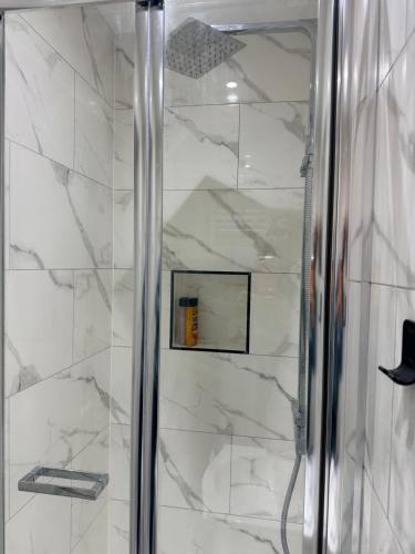 a shower with a glass door in a bathroom at Modern Studios Elephant and Castle in London
