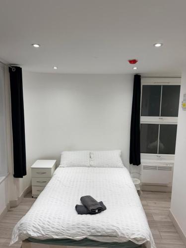 a bedroom with a white bed with a black bag on it at Modern Studios Elephant and Castle in London