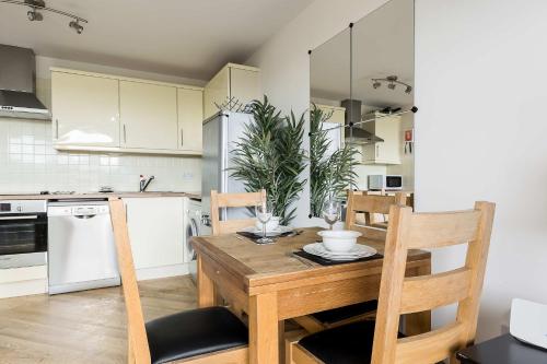 a kitchen and dining room with a wooden table and chairs at Bay Retreat- Moments from Hamworthy Park in Poole