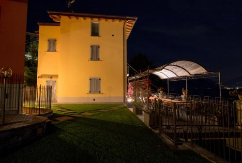 a yellow building with a white house and a telescope at Villa Perla del Lago in Vercana