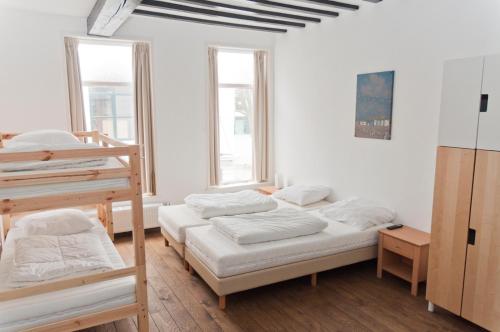 Cette chambre comprend 3 lits superposés et 2 fenêtres. dans l'établissement City Hostel Vlissingen, à Flessingue