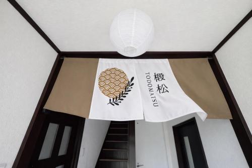 a sign on the ceiling of a building with a lantern at 椴松 l フルリフォーム l 貸切の一軒家 l 千歳空港まで30分 l Todomatsu in Yuni
