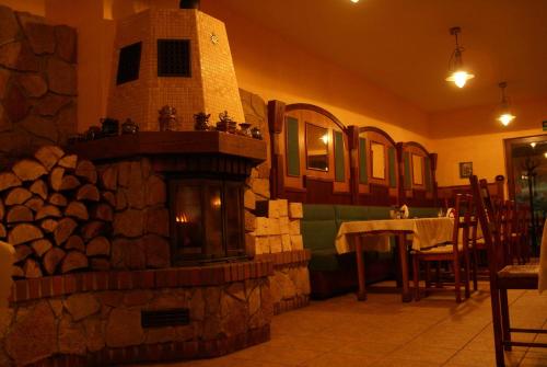 a large stone fireplace in a room with a table at Hotel Twardowski in Głogoczów