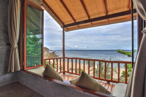 a room with a balcony with a view of the ocean at Sai Daeng Resort in Koh Tao
