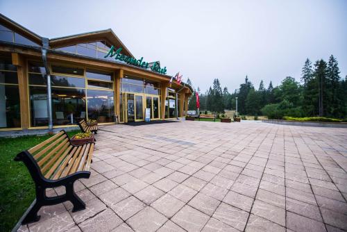 a building with two benches in front of it at MEANDER THERMAL & SKI REZORT ORAVICE in Oravice