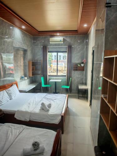 a bedroom with two beds and a table and chairs at Tuan Thanh Homestay in Tân Hiệp