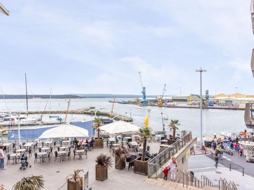 a marina with tables and chairs and boats in the water at Baywatch - Private Balcony Overlooking Poole Quay in Poole