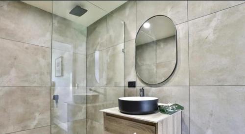 a bathroom with a sink and a mirror at Escape on Eighth Poolside Comfort Close to CBD in Mildura