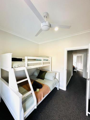 a bedroom with two bunk beds and a ceiling at Escape on Eighth Poolside Comfort Close to CBD in Mildura