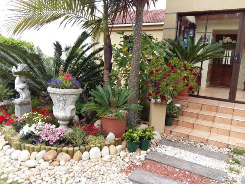 a garden with flowers and plants in front of a house at 110 Bay View in Brenton-on-Sea