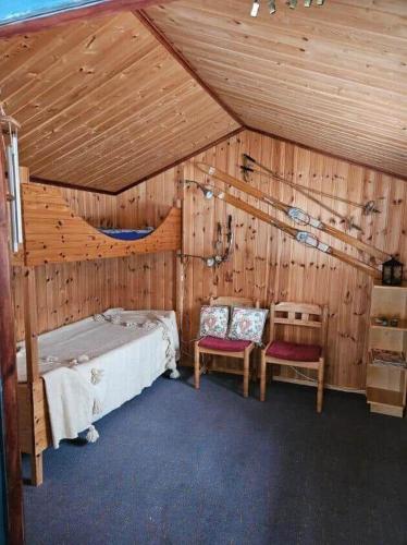 a bedroom with a bed and two chairs in a room at ORE798-Ramsberg-Kolarevaegen-2 in Ramsberg