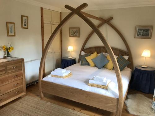 a bedroom with a canopy bed with towels on it at South Lodge in Lochgilphead