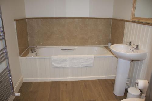 a bathroom with a tub and a sink and a toilet at School Room in Lochgilphead